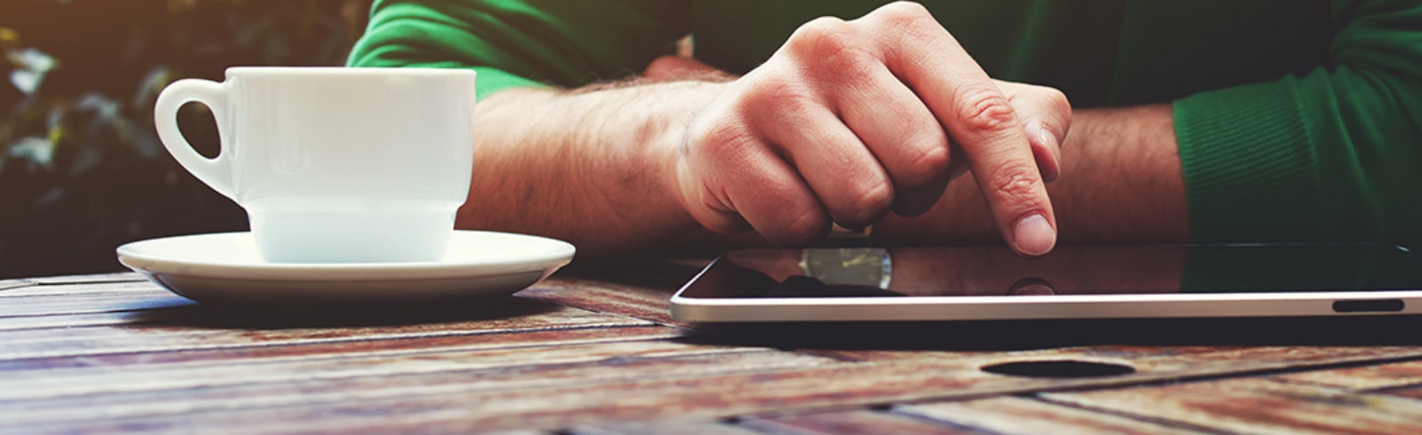 A man using a tablet on a table outside