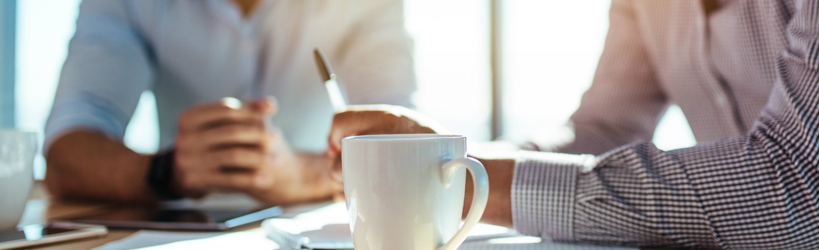 Office workers working with a close up of a mug