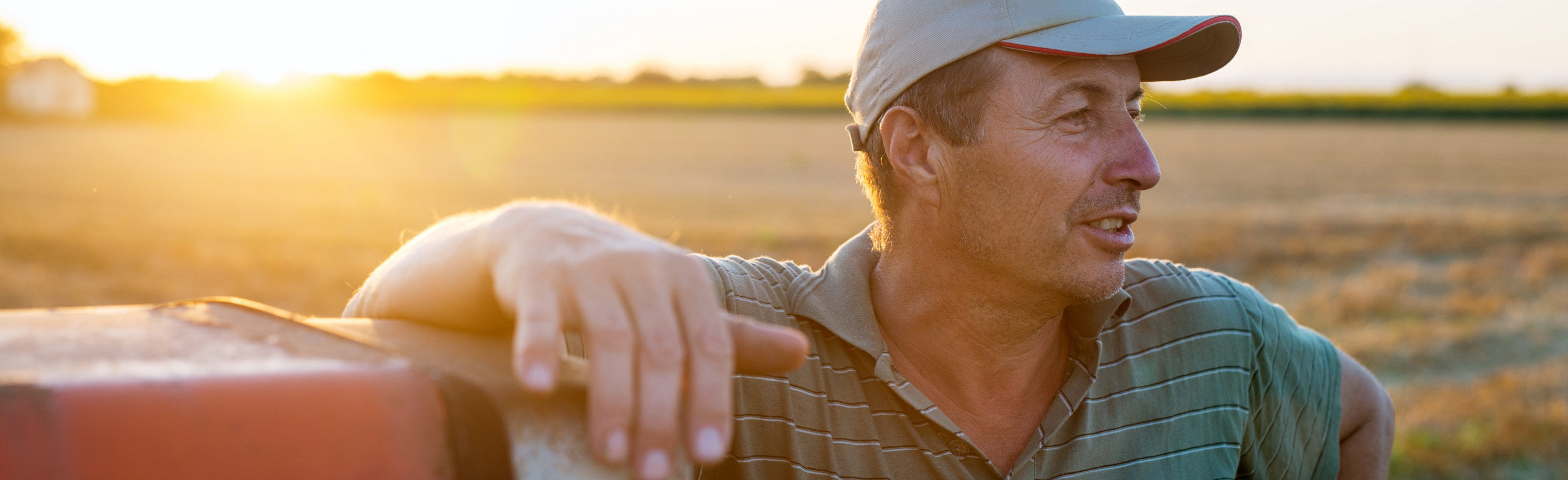 A farmer leaning against a tractor